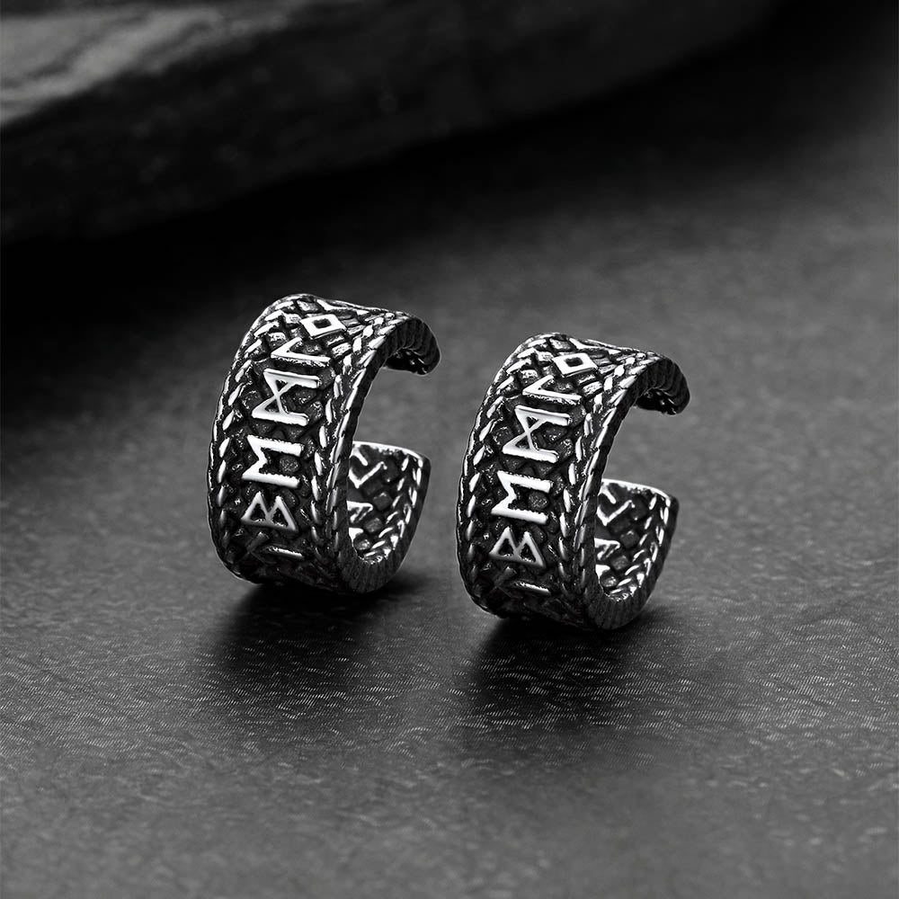 Pair of silver Viking-style earrings on a dark surface