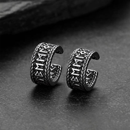 Pair of silver Viking-style earrings on a dark surface