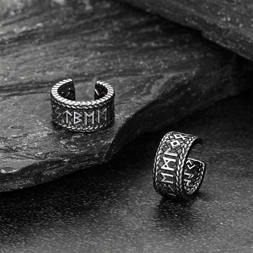 Pair of silver Viking-style ear cuff on a stone surface