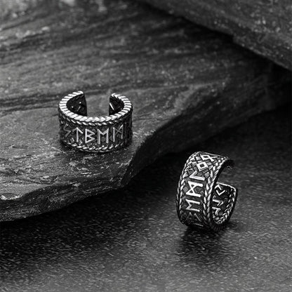 Pair of silver Viking-style ear cuff on a stone surface