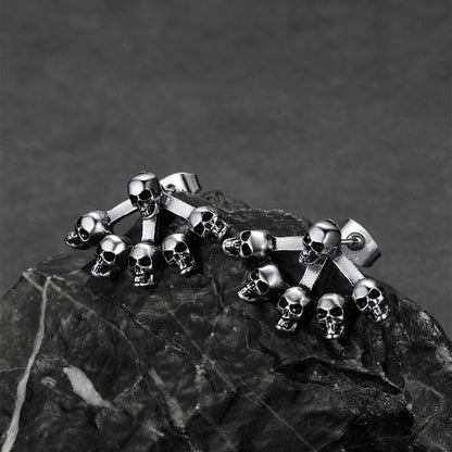 Skeleton skull stud earrings displayed with gothic jewelry collection.