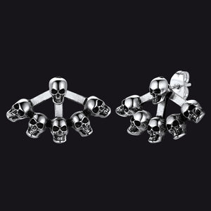 Gothic style skull head stud earrings for men on dark textured background.