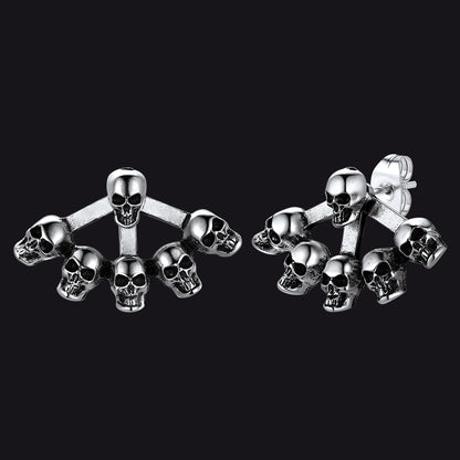 Gothic style skull head stud earrings for men on dark textured background.