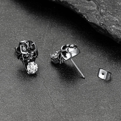 Stainless steel cubic zirconia skull earrings displayed on dark background.