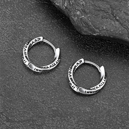 Pair of silver hoop earrings on a textured gray surface