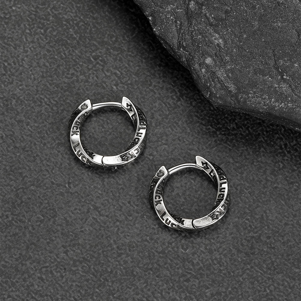 Silver hoop earrings on a textured gray surface