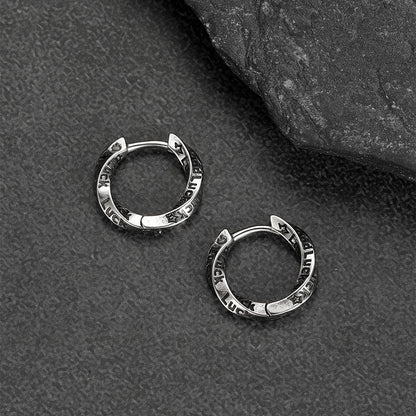 Silver hoop earrings on a textured gray surface