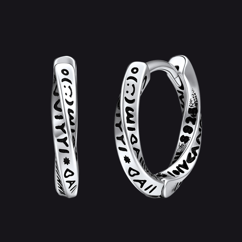 Silver hoop earrings with intricate designs on a black background