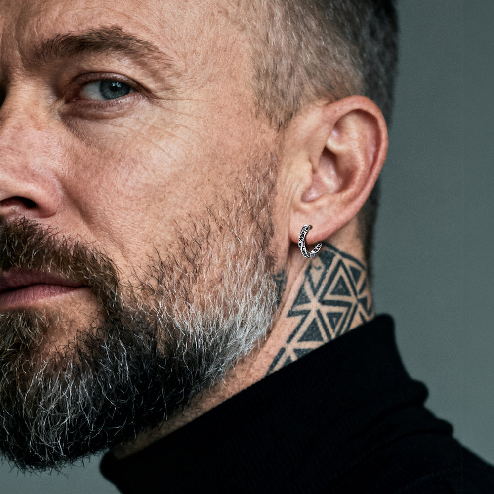 Close-up of a man with a beard and neck tattoo wearing Mobius Hoop Earrings 