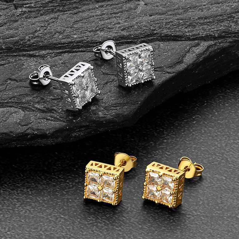 Gold and silver square stud earrings on a dark stone surface
