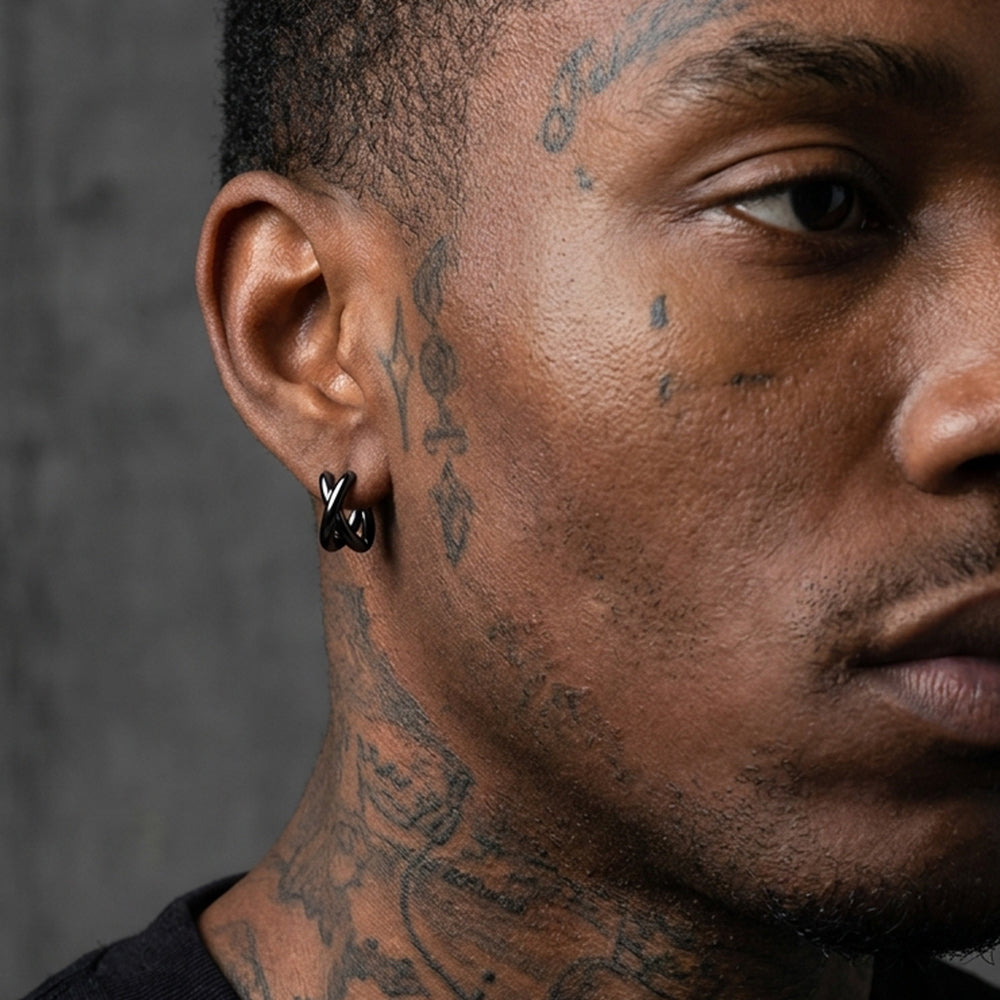 Close-up of a man's face with tattoos and an earring against a dark background