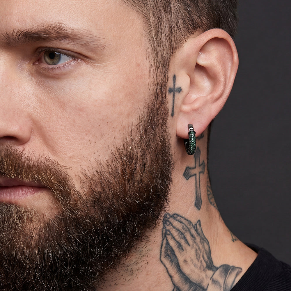 Close-up of a man with tattoos on his neck and ear, wearing a black earring.