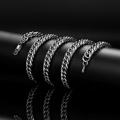 Silver chain bracelets stacked on a black surface