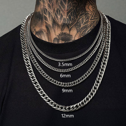 Four silver chain necklaces of different widths displayed on a person wearing a black shirt.