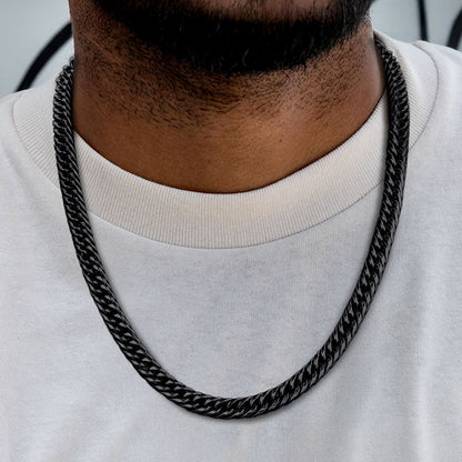 Black chain necklace worn by a person on a white background