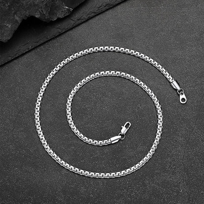 Silver chain necklace on a dark surface