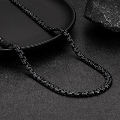 Black chain necklace on a dark surface