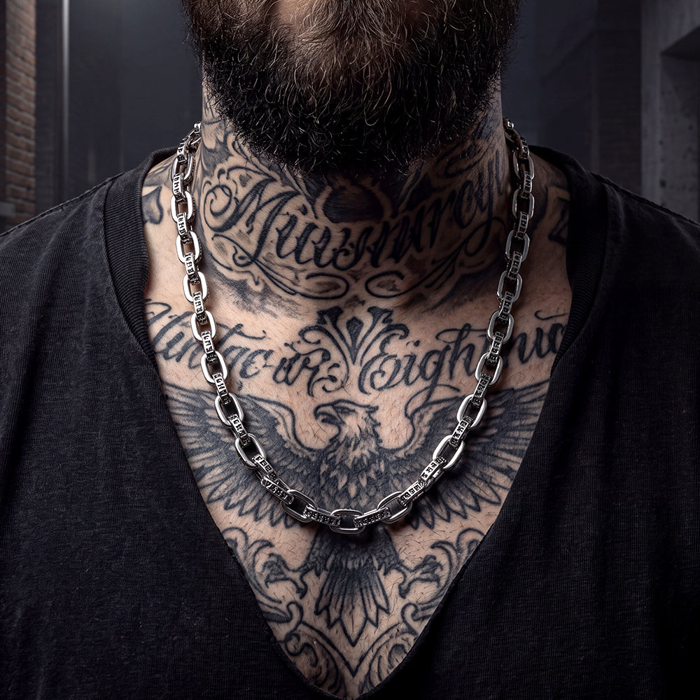 A close-up of a man wearing a chunky silver Mantra Vajra Paperclip Chain