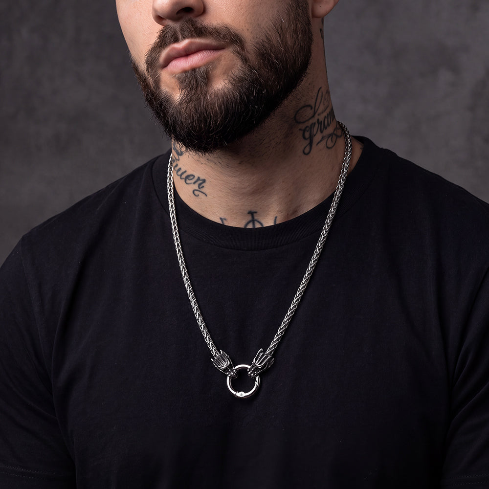 A close-up of a man wearing a silver Norse Viking Dragon Head Braided Leather Necklace