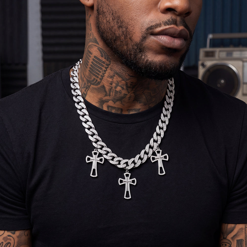 Man wearing a black shirt with a silver chain necklace featuring cross pendants.
