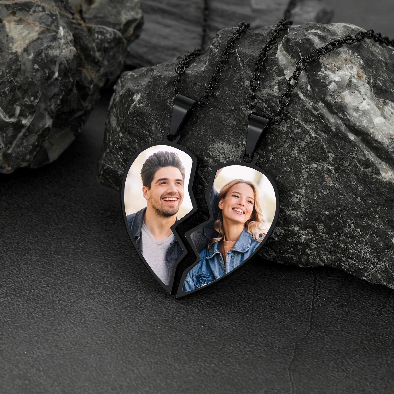 Heart-shaped photo necklace with two halves on a dark stone surface