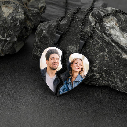 Heart-shaped photo necklace with two halves on a dark stone surface