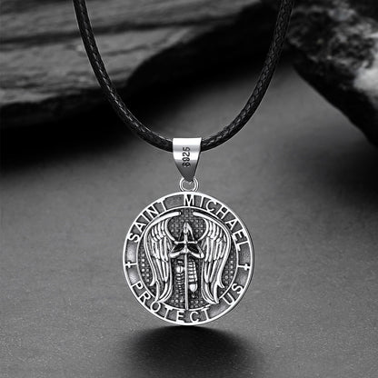 Silver Saint Michael pendant on a black leather cord against a gray background