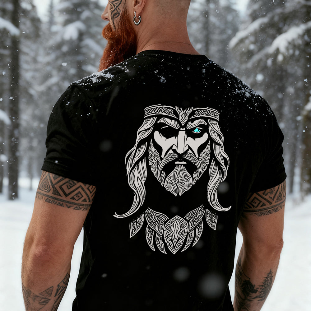 Man wearing a black Odin t-shirt with a Viking design in a snowy forest
