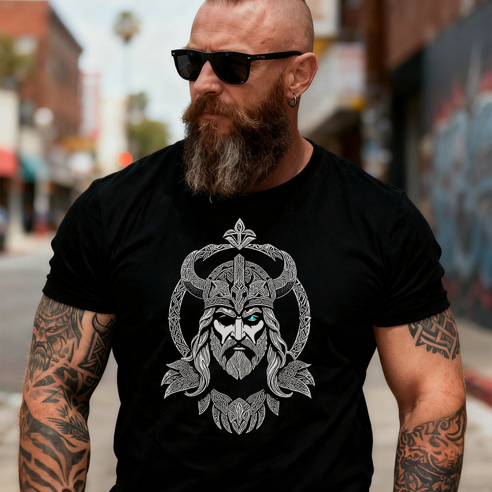Man wearing a black t-shirt with a viking design on a city street.