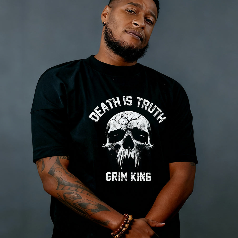 Man wearing a black t-shirt with a skull design and text against a gray background