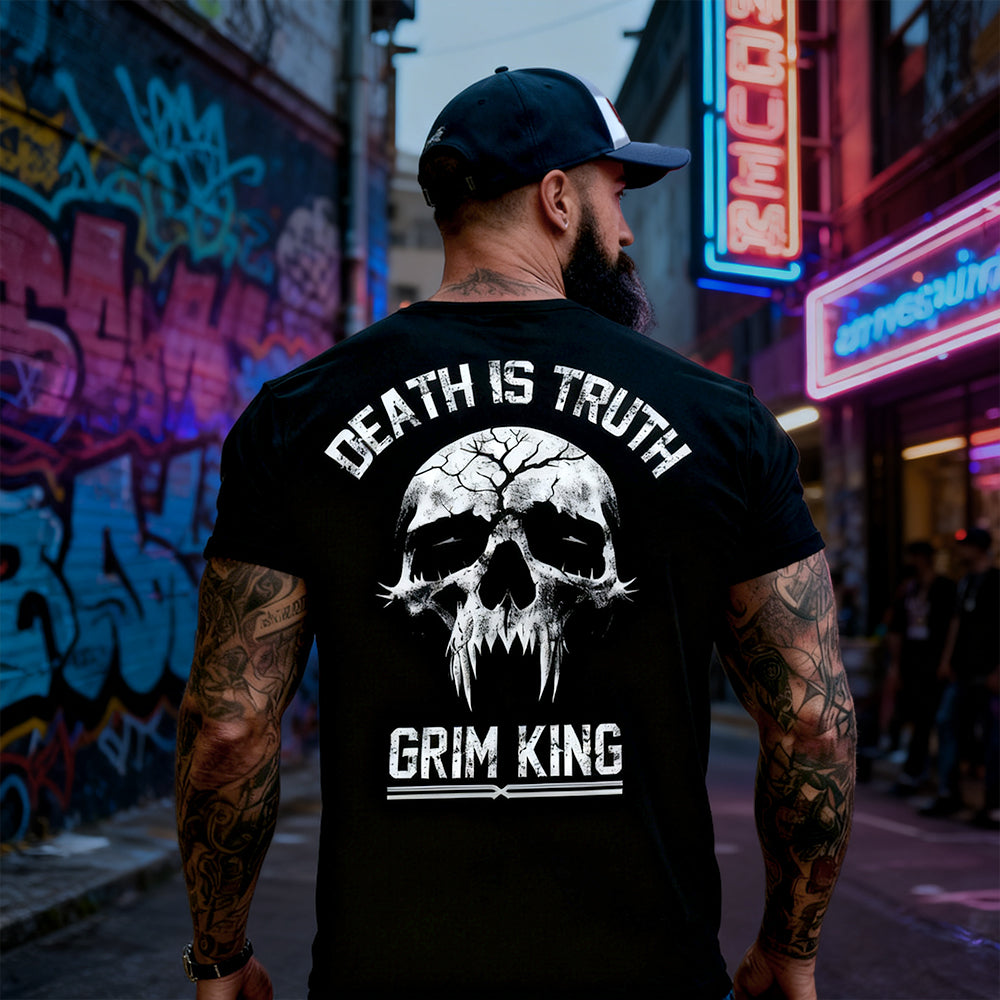Man wearing a black t-shirt with a skull design and text in an urban setting with graffiti and neon signs.