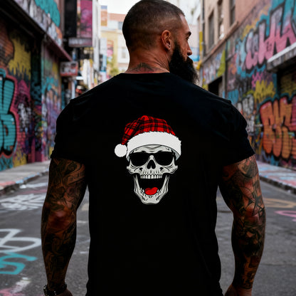 Man wearing a black t-shirt with a skull wearing a Santa hat graphic in an urban setting with graffiti.