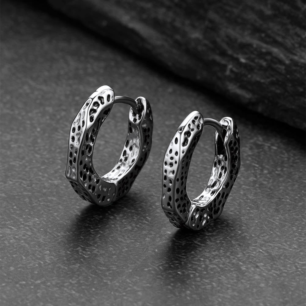 Pair of silver hoop earrings on a dark textured surface