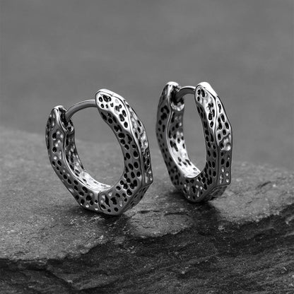 Pair of silver hoop earrings on a dark stone surface