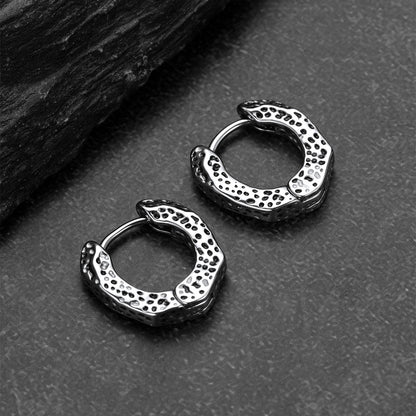 Pair of silver hoop earrings on a textured surface