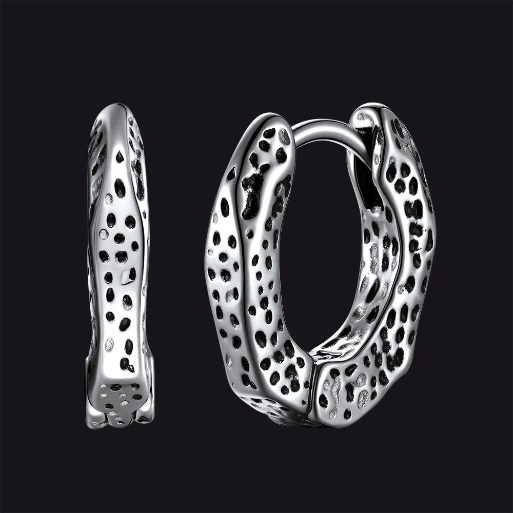 Silver hoop earrings with a textured design on a black background