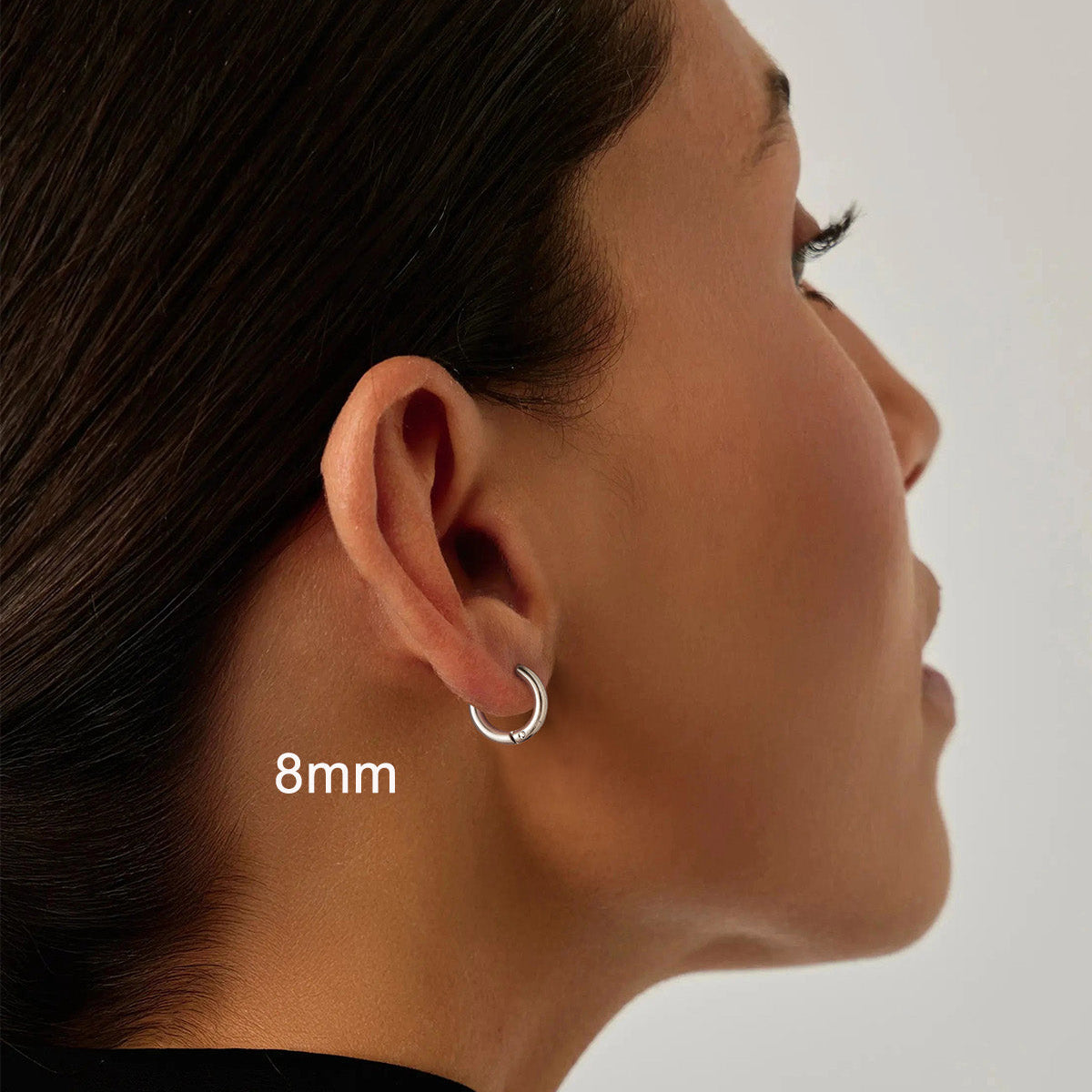 Close-up of an ear wearing a silver hoop earring with '8mm' for women
