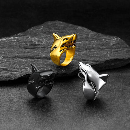 Three shark-shaped rings in gold, black, and silver