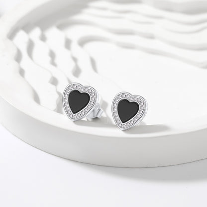 Heart-shaped earrings with black centers on a white dish