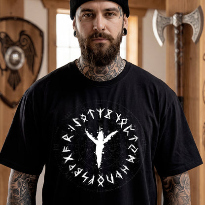 Man wearing a black t-shirt with a white viking rune design in a room with Viking-themed decor.
