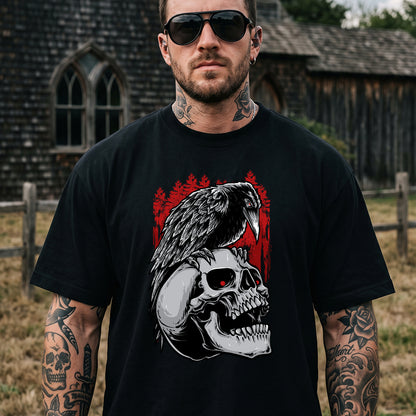 A man wearing a black graphic t-shirt with a detailed design of a skull, crow, and red background, standing outdoors in front of a rustic wooden building.