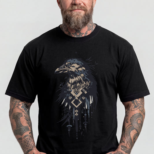 A man wearing a black short-sleeve t-shirt with a detailed graphic of a raven in shades of blue, beige, and white, featuring geometric patterns.img