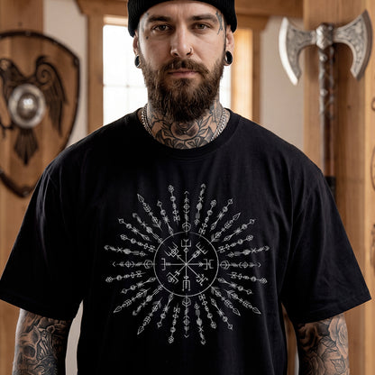 Man wearing a black t-shirt with a Viking Rune design, standing in a room with wooden walls and decorative items.