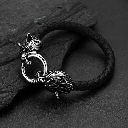 Viking wolf-head leather bracelet set against a dark gray rock background.
