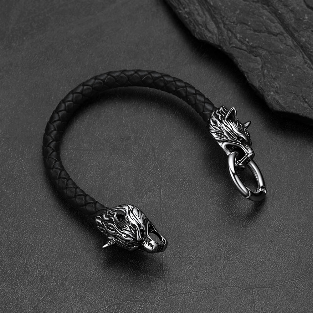 Viking wolf-head leather bracelet set against a dark gray rock background.