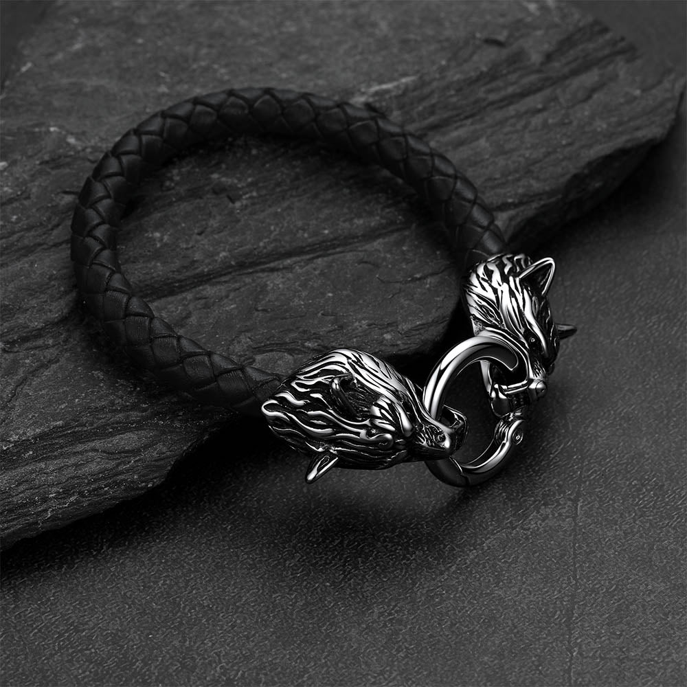 Viking wolf-head leather bracelet set against a dark gray rock background.