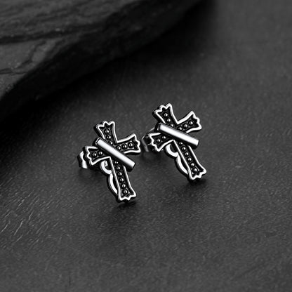 Close-up of vintage crucifix cross stud earring with antique finish, detailed retro religious jewelry for men
