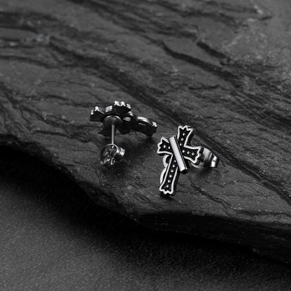 Close-up of vintage crucifix cross stud earring with antique finish, detailed retro religious jewelry for men