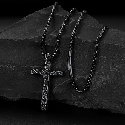 Men's vintage hammered-texture cross necklace on a grey rock