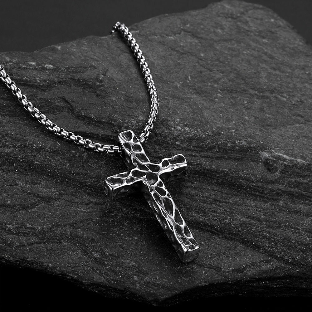 Men's vintage hammered-texture cross necklace on a grey rock